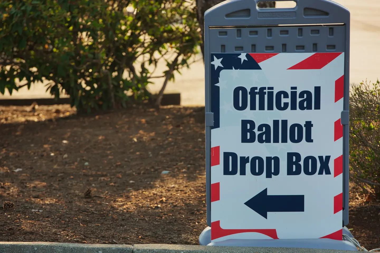 Illustrative scene, not evidence for this record: A sign pointing to an official ballot drop box.