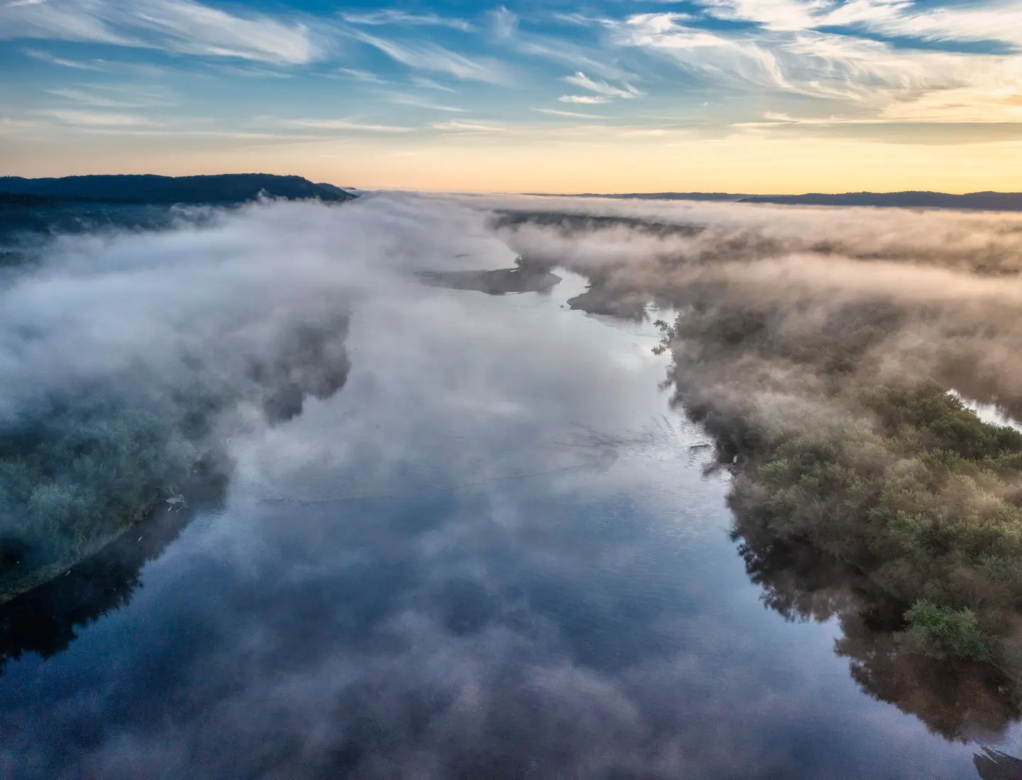 Illustrative scene, not evidence for this record: A foggy river valley at sunrise near Trevino, Wisconsin.