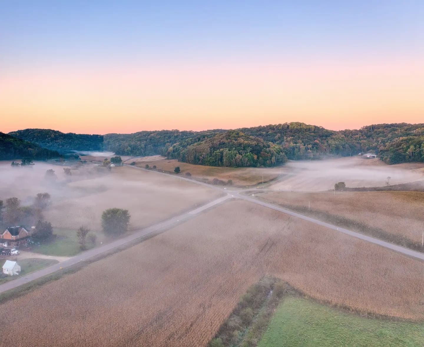 Illustrative scene, not evidence for this record: Misty farmland at sunrise near Urne, Wisconsin.