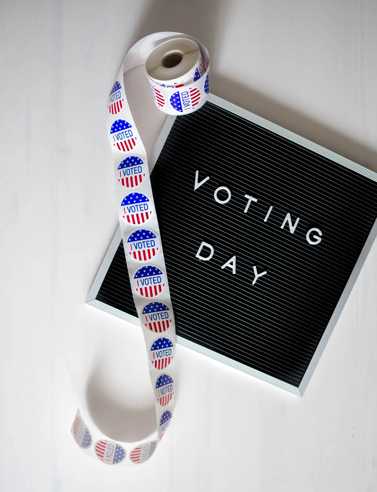 Illustrative scene, not evidence for this record: A voting day sign and a roll of I Voted stickers.