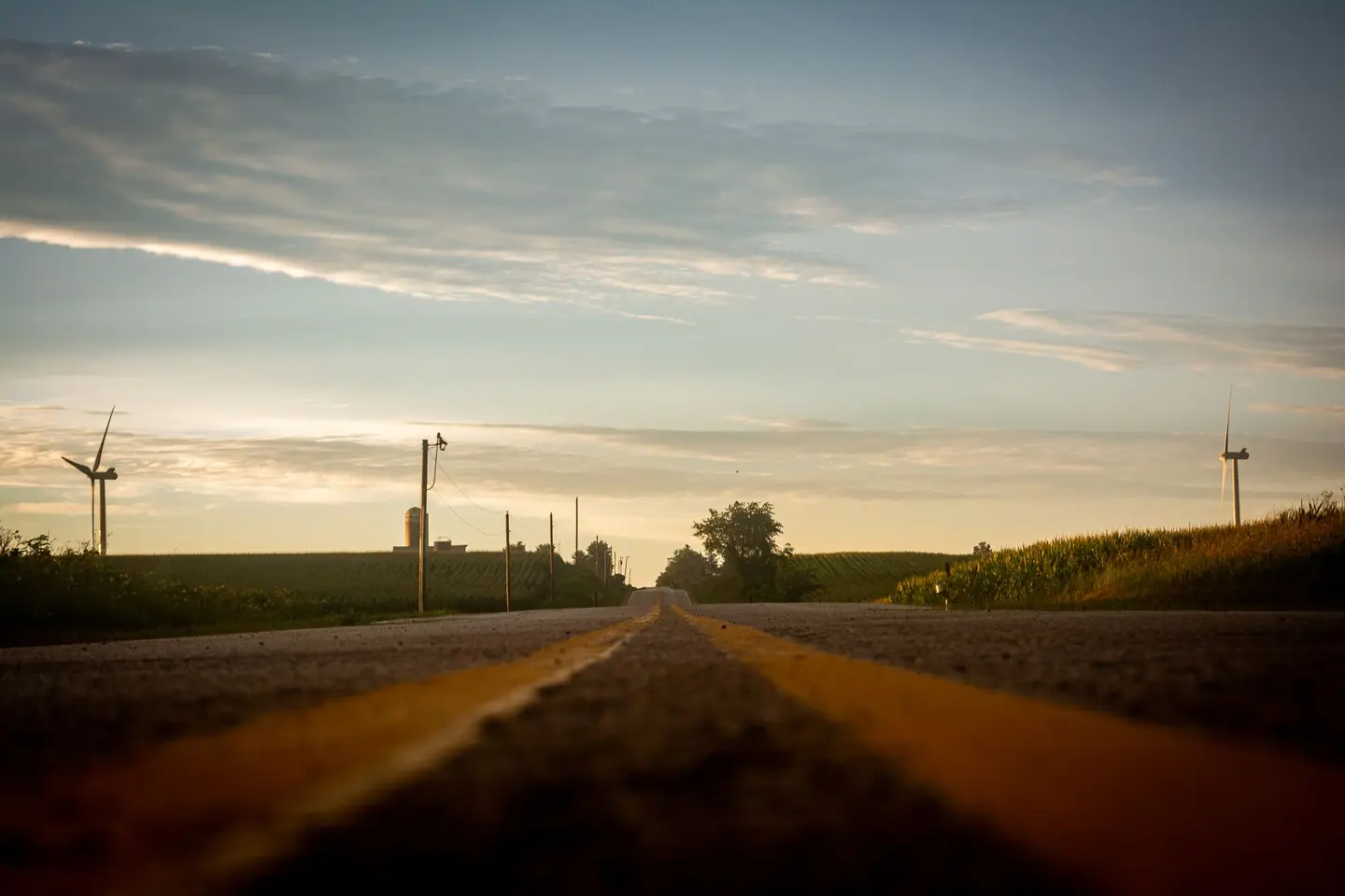 Illustrative scene, not evidence for this record: A countryside road in Wisconsin at dawn with wind turbines.
